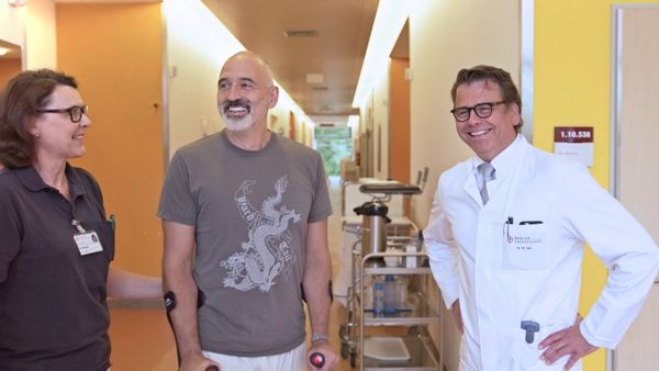 Dr. med. Roman Feil und ein Patient lachen