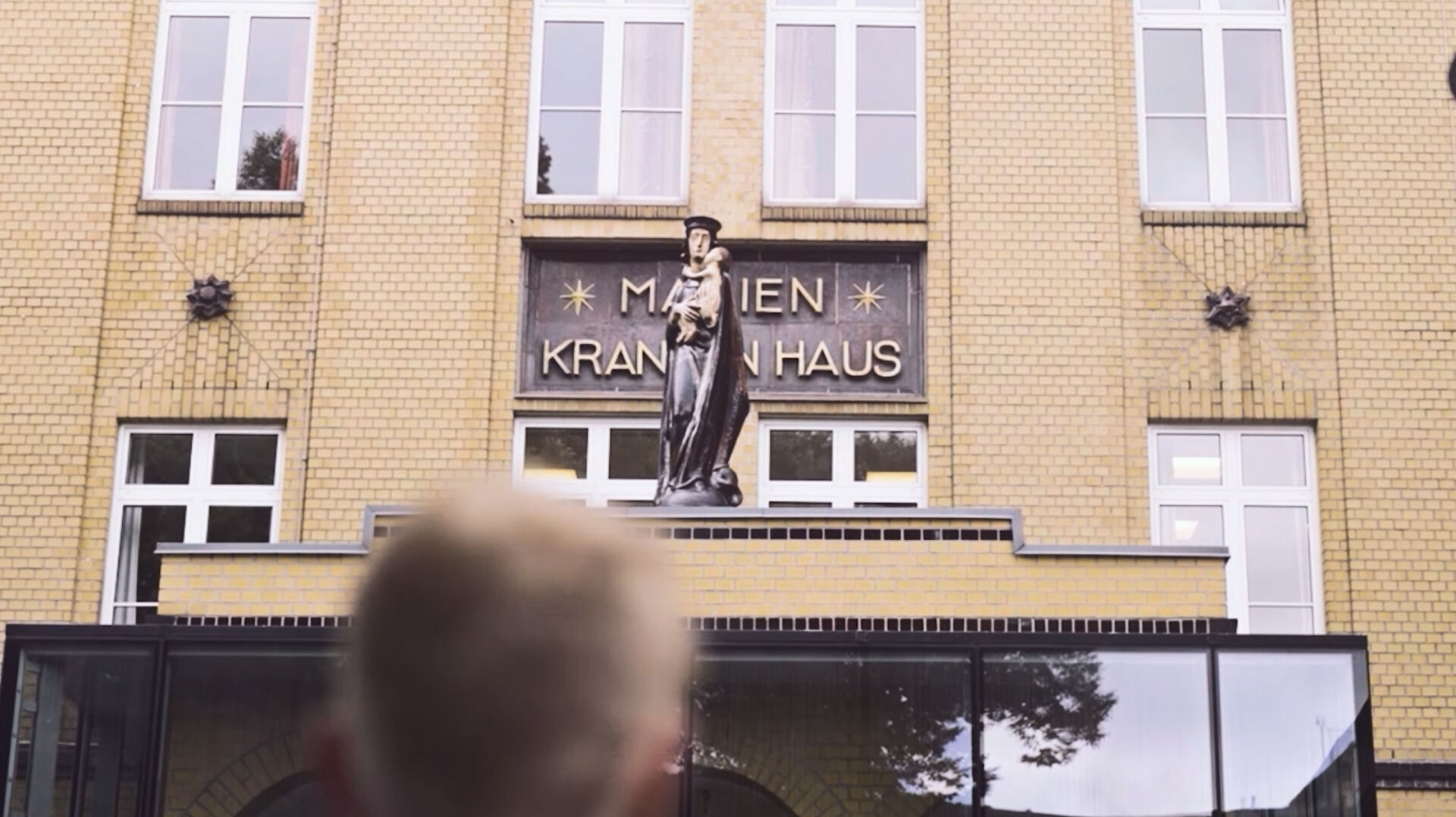 Eingang des Marienkrankenhauses mit Statue einer stehenden Frau über dem Schriftzug.