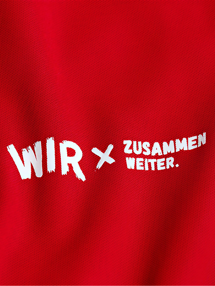 Roter Stoff mit dem Text "WIR x ZUSAMMEN WEITER." in weißer Schrift.