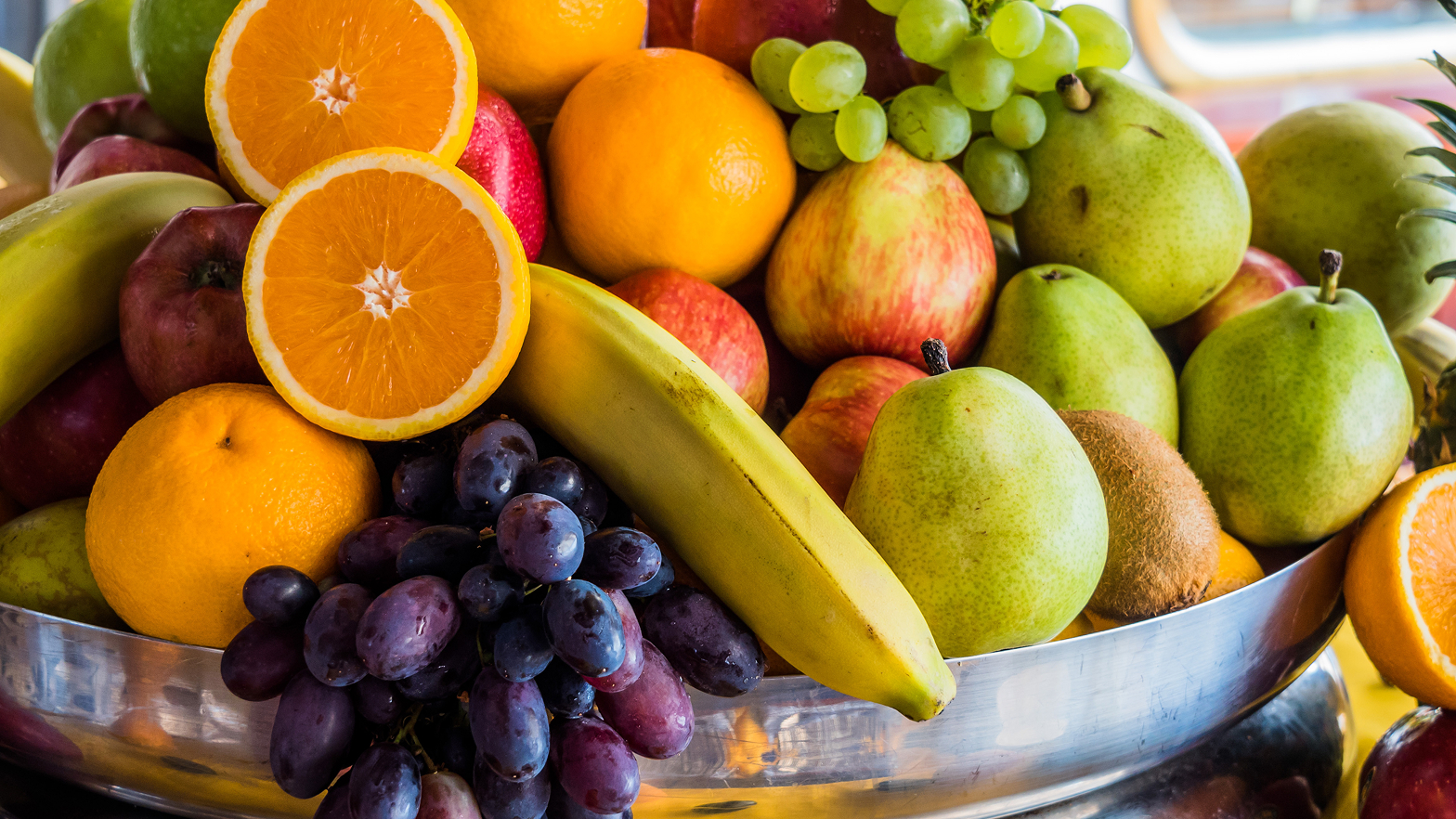 Bunte Obstschale mit Äpfeln, Birnen, Trauben, Orangen und Bananen.