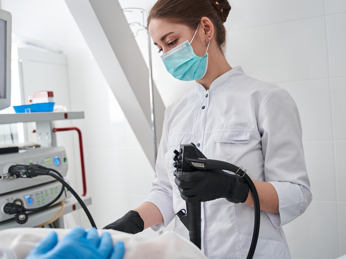 Eine Fachkraft in Schutzkleidung führt eine Behandlung an einem Patienten durch.