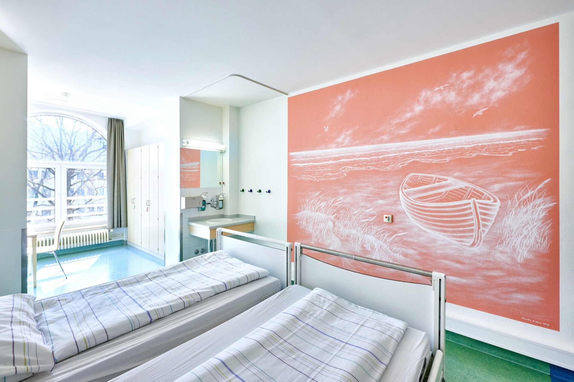 Helles Zimmer mit zwei Betten, einem großen Fenster und einer Wandmalerei eines Bootes auf korallenfarbenem Hintergrund.