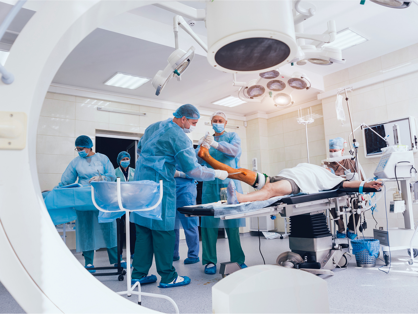 Chirurgisches Team in einem modernen Operationssaal, das einen Patienten auf dem Tisch behandelt.